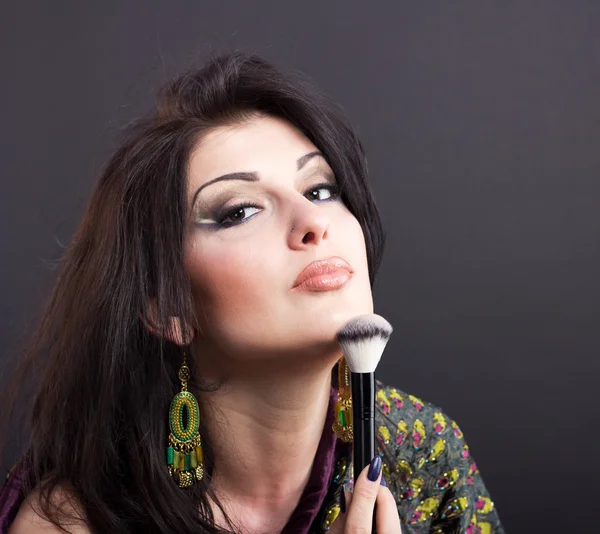 Beautiful brunette apply makeup in bright clothes. Portrait of a well-groomed woman. — Stock Photo, Image