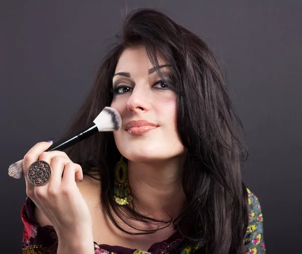 Beautiful brunette apply makeup in bright clothes. Portrait of a well-groomed woman. — Stockfoto