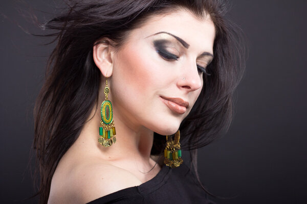 Красивая брюнетка с летящими волосами. Портрет красивой девушки в ювелирном магазине. Блестящие волосы. Мода. Украшения на красивой женщине
