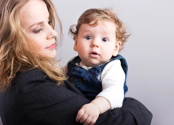 Giovane madre con un bambino tra le braccia. Ritratto di madre e figlio. Bella bionda. bambino pettorale. famiglia felice — Foto Stock