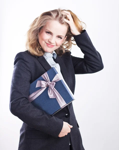 Gelukkig zakenvrouw met een cadeau. Portret van een blonde in een jasje op een wit. — Stockfoto