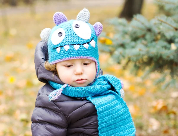 Happy baby i en rolig hatt på en promenad. Gångavstånd utomhus på hösten. Höstlöv — Stockfoto