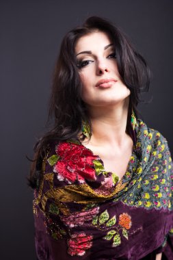 Siyah bir zemin üzerine parlak kıyafetleri çekici esmer. Moda portre. Güzel bir esmer portresi. Parlak işlemeli mendil