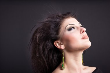 Güzel esmer ile uçan bir saç. Mücevher bir güzel kız portresi. Parlak saçlar. Moda. Güzel kadın süsler