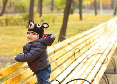 Neşeli çocuk oyuncak ayı şeklinde bir kap içinde. Mutlu çocuk bir yürüyüş. Sonbaharda havada çocuktur