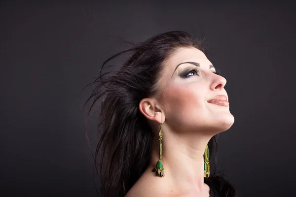 Linda morena com um cabelo voador. Retrato de uma menina bonita nas jóias. Cabelo brilhante. Moda. Ornamentos na mulher bonita — Fotografia de Stock