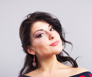 Mükemmel yüz güzel bir esmer. Güzel bir kadın portresi. Gri bir arka plan üzerinde güzel esmer