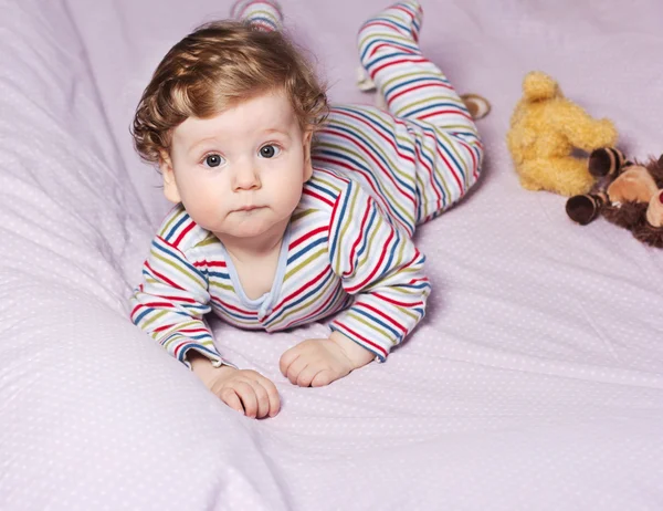 Beautiful baby with a lovely toy. The child in the crib. — Stock Photo, Image