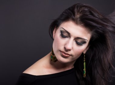 Güzel esmer ile uçan bir saç. Takı güzel bir kızın portresi. Parlak saçlar. Moda. Güzel kadın süsler