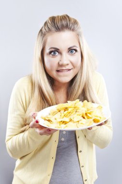 Patates cipsi ile genç kız. O düşünüyor. Sarışın izle diyet