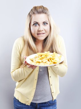 Patates cipsi ile genç kız. O düşünüyor. Sarışın izle diyet