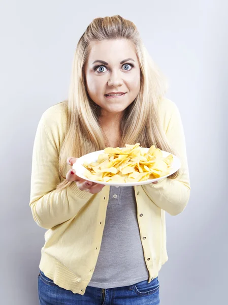 Young girl with potato chips. She thinks. Blonde watch your diet Stock Photo