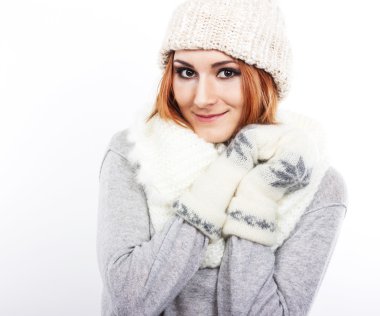 Genç kız bir yün şapka ve atkı. Bir kız sıcak giyinmiş. Kış soğuk. Beyaz bir arka plan üzerinde büyük gözlü bir kız portresi