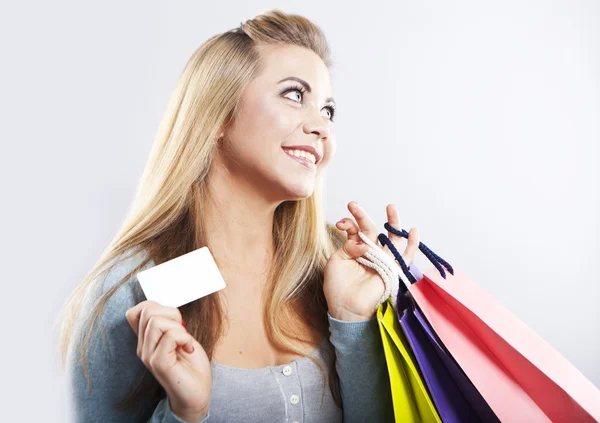 Happy blonde woman hold shopping bag. Shopping with credit card. Smiling girl Royalty Free Stock Photos