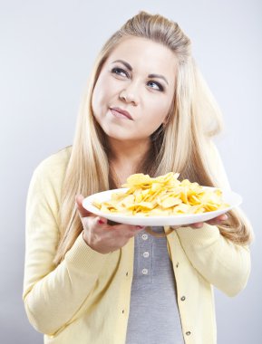 Patates cipsi ile genç kız. O düşünüyor. Sarışın izle diyet