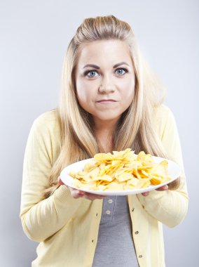 Patates cipsi ile genç kız. O düşünüyor. Sarışın izle diyet