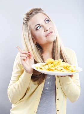 Patates cipsi ile genç kız. O düşünüyor. Sarışın izle diyet