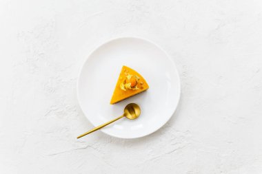 Bir dilim ev yapımı balkabağı ve beyaz tabakta fitalis ile portakallı turta. Yatay yönelim, üst görünüm.