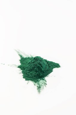 Beyaz arka planda yeşil spirulina yığını.