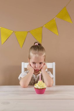 Kekin yanındaki küçük kızı gücendirdim. Kötü doğum günü konsepti.