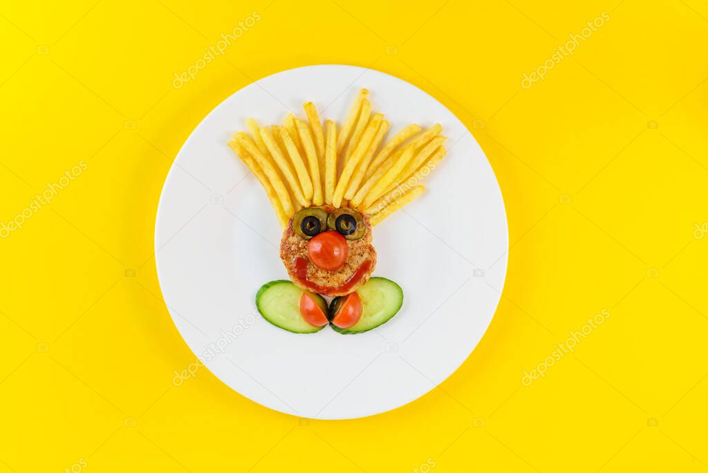 Kid's dish in the form of a clown on a yellow background.