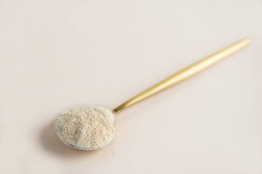 Bej bir arka planda, kaşıkta lecithin ayçiçeği.