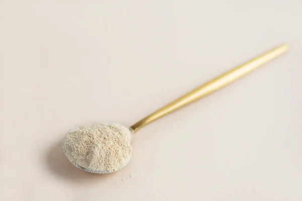 Bej bir arka planda, kaşıkta lecithin ayçiçeği.