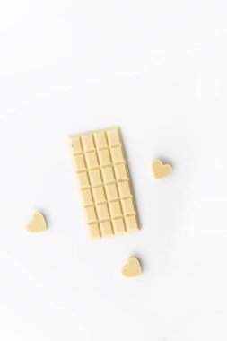 Beyaz arka planda kalpleri olan beyaz çikolata. Sevgililer Günü. Şeker, glüten, laktozsuz.