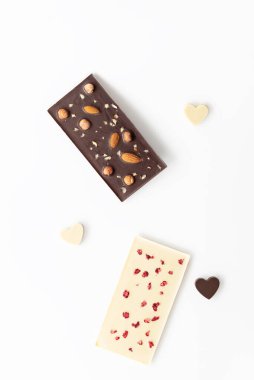 Açık arkaplanda ahududu ve fındıklı ev yapımı beyaz ve siyah çikolata. Sevgililer Günü.
