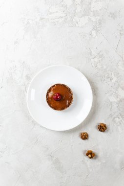 Beyaz tabakta kirazlı muzlu kek. Çiğ tatlı, sağlıklı yemek. Şeker, glüten ve laktozsuz. Dikey yönelim, üst görünüm.