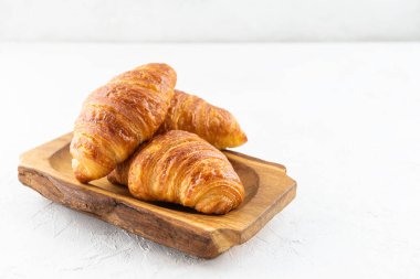 Hafif arka planda ahşap bir kruvasan..