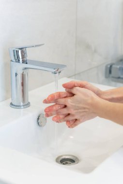 Banyoda musluğun altında ellerini yıkamak..