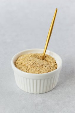 Gri arka planda beyaz bir kasede pasif maya. Sağlıklı gıda konsepti.