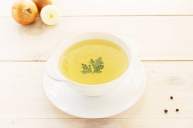 Ev yapımı tavuk kemiği çorbası maydanozlu ve ahşap bir masada baharatlı..