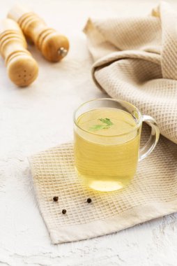 Cam bardakta tavuk kemiği çorbası ve keten havlu..