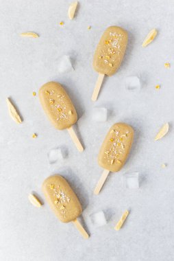 Çikolatalı kaju ve gri arka planda mango parçaları ile ev yapımı buzlu dondurma. Dikey yönelim, üst görünüm.