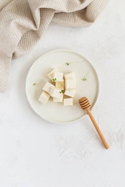 Beyaz tabakta mikro yeşillikli soya peyniri. Dikey yönelim, üst görünüm.