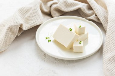 Hafif tabakta keten havluyla mikro yeşillik ve tofu peyniri parçaları. Seçici odak.