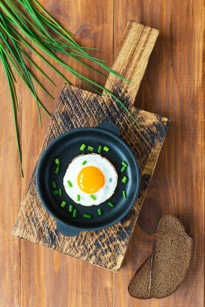Tahtadaki Dökme Demir Tavada Yeşil Soğanlı Sahanda Yumurta Dikey Yönelim — Stok fotoğraf
