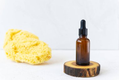 Hafif arka planda deniz süngeri olan cam yağ şişesi ya da serumlar. Doğal yaz yüzü ve vücut bakımı kavramı.