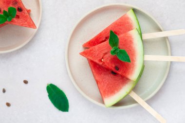 Nane yapraklı tahta bir çubukta karpuz dilimleri. Yatay yönelim, üst görünüm, düz yatış.