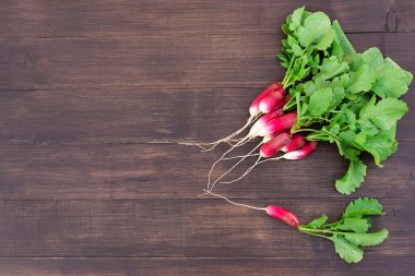 Ahşap bir masada bir grup kırmızı turp. Yatay yönelim, kopyalama alanı, üst görünüm.