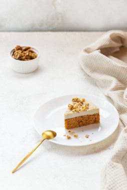 Beyaz tabakta cevizli havuçlu kek..