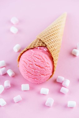 Pembe arka planda marşmelovlu waffle külahında pembe dondurma..
