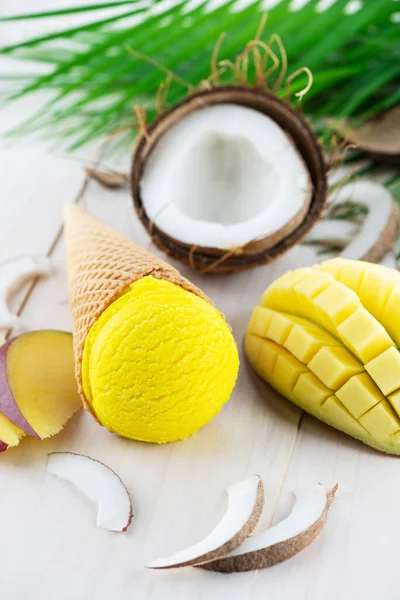 Tropical ice cream with mango and coconut on a light background.