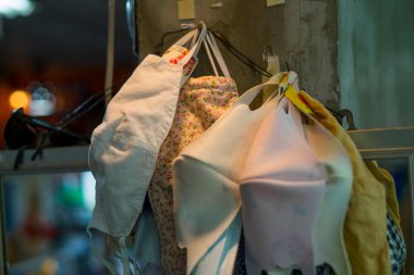 Duvarda asılı yüz maskeleri arasında tıbbi maske, bez maske ve inşaat maskesi var. Solunum maskelerine kıyasla standart yüz maskelerinin etkinliği kavramı