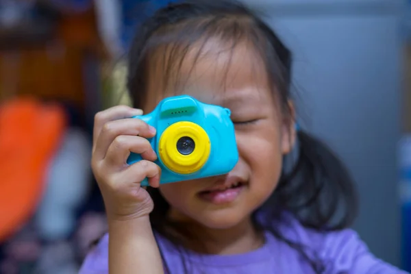 taking pictures of others. Little girl taking picture using toy camera, Photography courses. Camera in hand