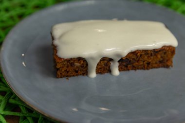 Gri seramik tabakta krema soslu havuçlu kek.