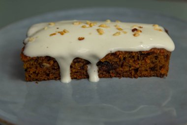 Gri seramik tabakta krema soslu havuçlu kek.