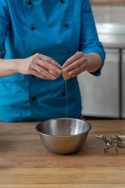 Şekerci bir yumurtayı metal bir kaseye kırar.